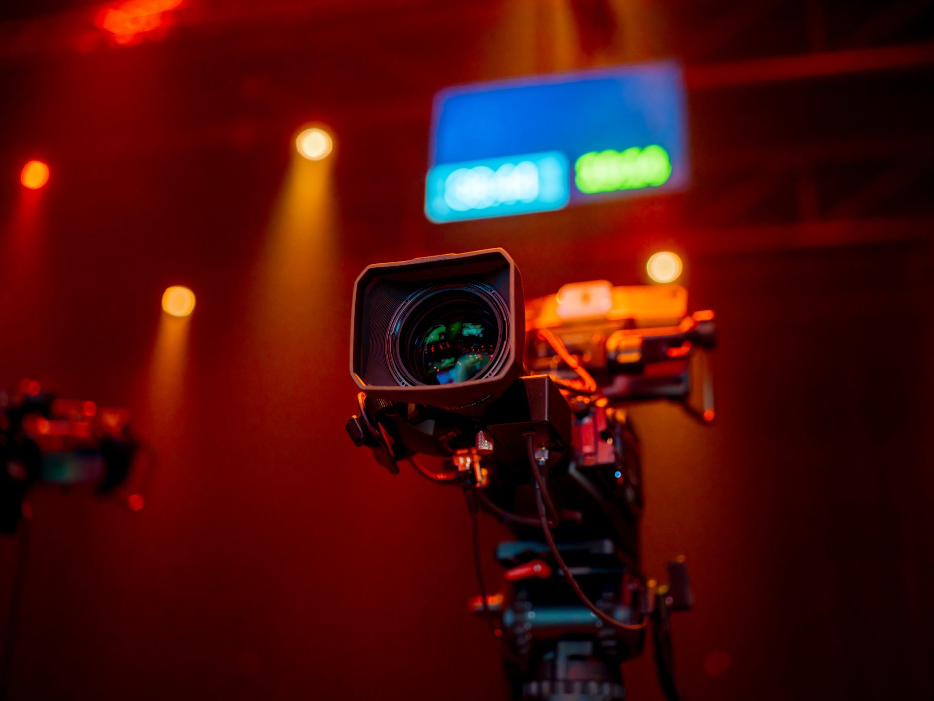 Cinema camera on rig with colored studio lighting
